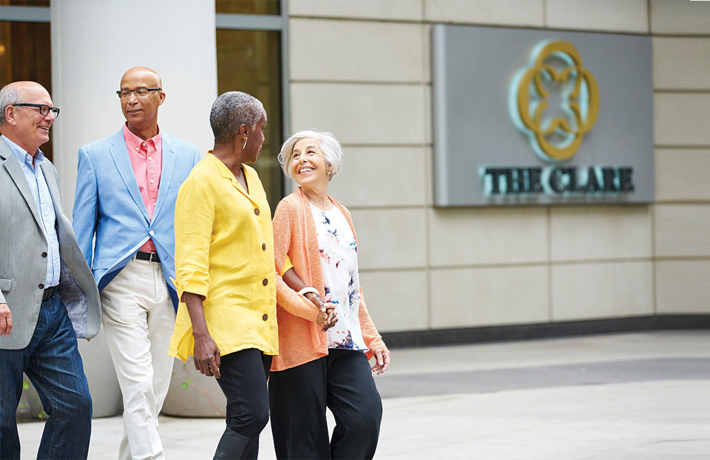 Luxury-Retirement-Desktop Two senior couples walking out side of The Clare building in Chicago